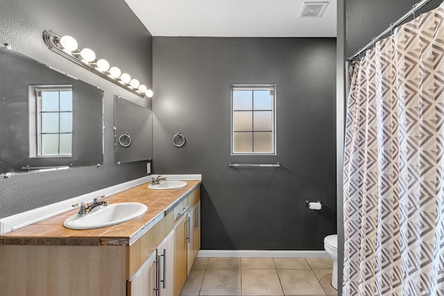 bathroom with tile patterned flooring, vanity, and toilet