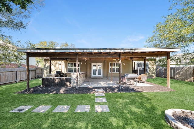 rear view of house with a lawn, french doors, ceiling fan, area for grilling, and a patio