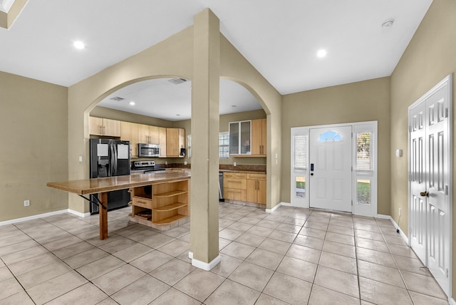 kitchen featuring appliances with stainless steel finishes, light tile patterned floors, and light brown cabinetry