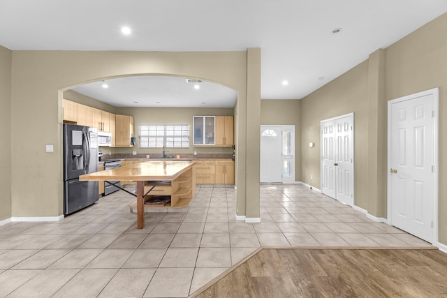 kitchen featuring stainless steel appliances, light brown cabinetry, and light hardwood / wood-style flooring