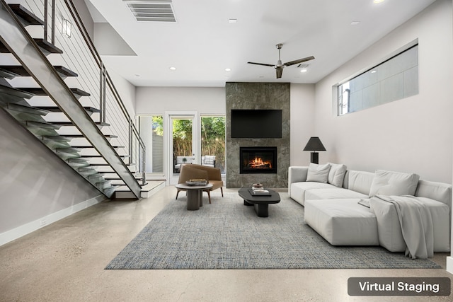 living room with ceiling fan and a large fireplace