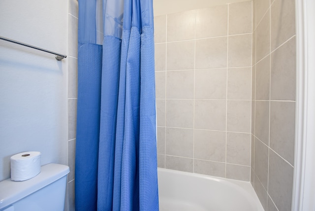 bathroom featuring shower / tub combo with curtain and toilet