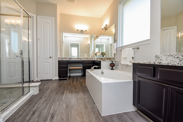 bathroom with wood-type flooring, vanity, and shower with separate bathtub