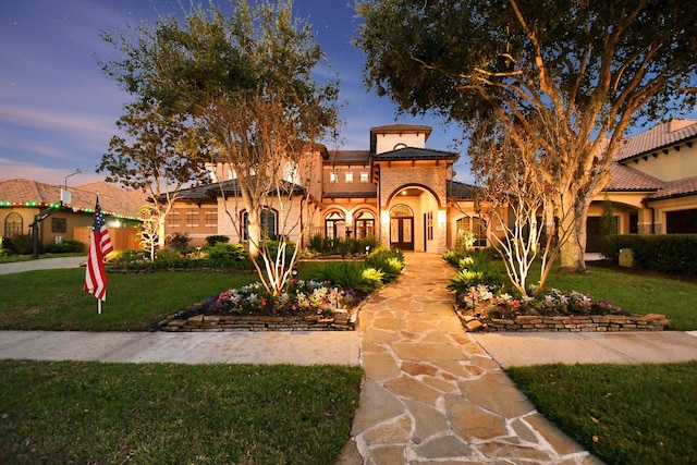 mediterranean / spanish-style home with a yard