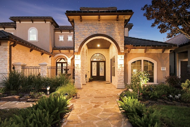 exterior entry at dusk featuring french doors