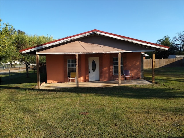 rear view of house featuring a yard