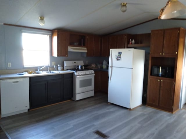 kitchen with white appliances, hardwood / wood-style flooring, lofted ceiling, and sink