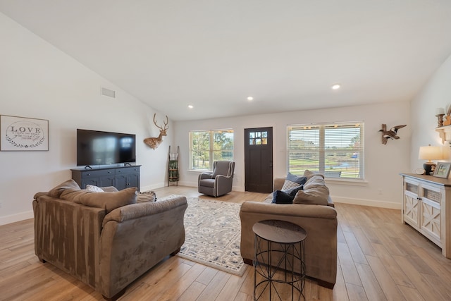 living room with light hardwood / wood-style floors and lofted ceiling