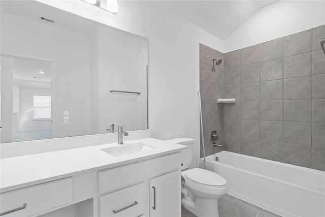 full bathroom featuring tile patterned floors, vanity, tiled shower / bath combo, toilet, and lofted ceiling