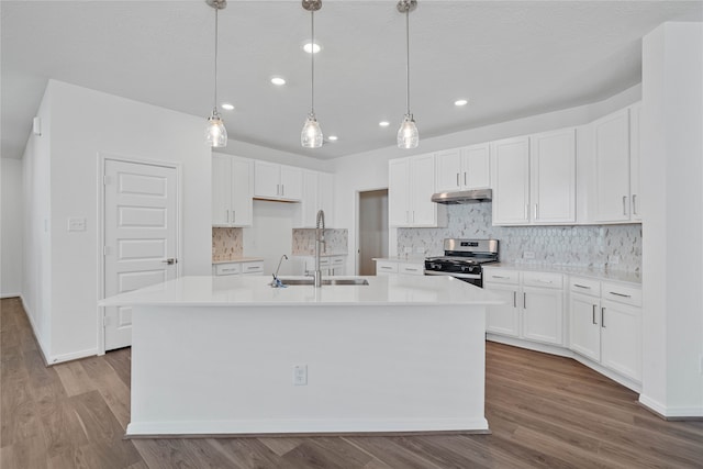 kitchen featuring gas stove, white cabinetry, and a kitchen island with sink