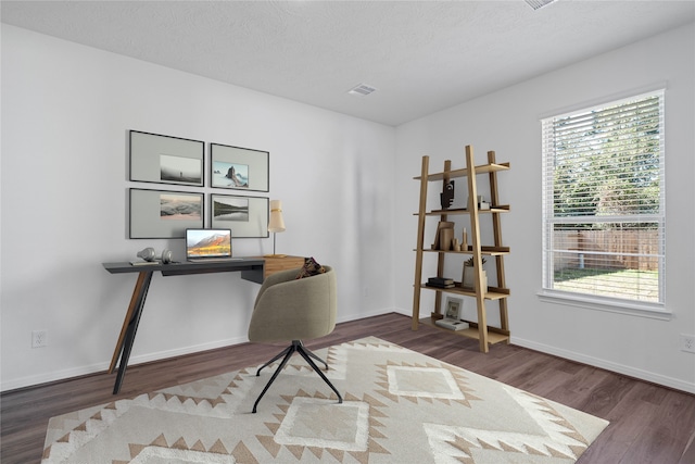 office with a wealth of natural light, dark hardwood / wood-style flooring, and a textured ceiling