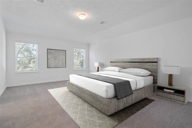 bedroom featuring a textured ceiling and light colored carpet