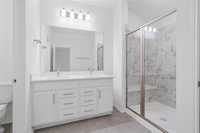 bathroom with vanity, a shower with door, tile patterned flooring, and toilet