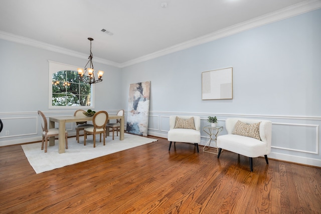 dining space featuring hardwood / wood-style floors, an inviting chandelier, and ornamental molding