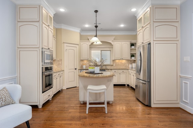 kitchen featuring hardwood / wood-style flooring, a center island, hanging light fixtures, and appliances with stainless steel finishes