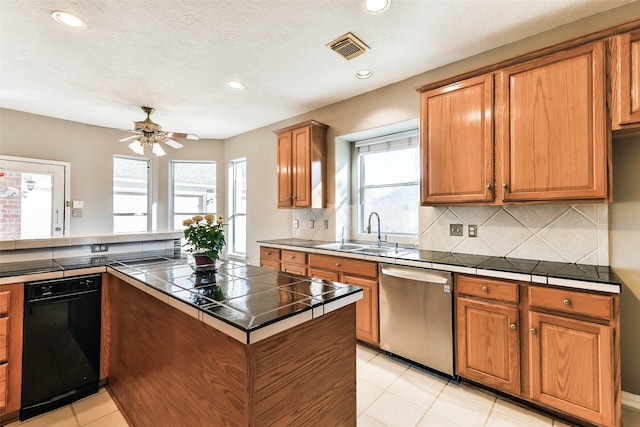 kitchen featuring ceiling fan, sink, stainless steel dishwasher, tile countertops, and decorative backsplash