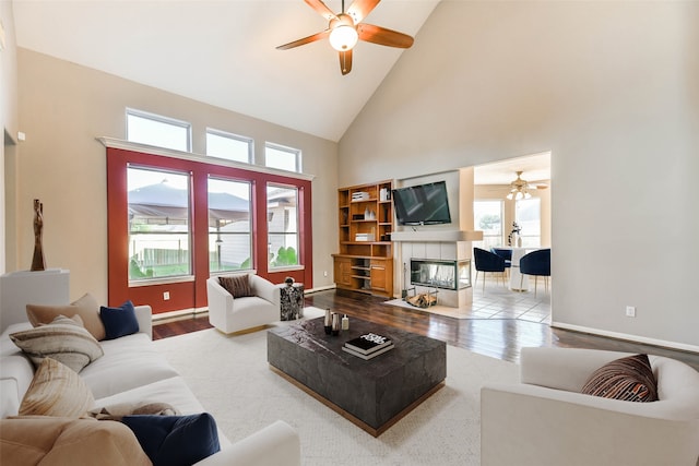 living room with a fireplace, hardwood / wood-style floors, high vaulted ceiling, and plenty of natural light