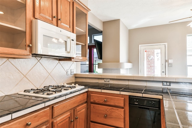 kitchen featuring white appliances, tile countertops, tasteful backsplash, and ceiling fan