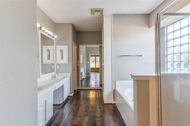 bathroom featuring a bath, vanity, and hardwood / wood-style flooring