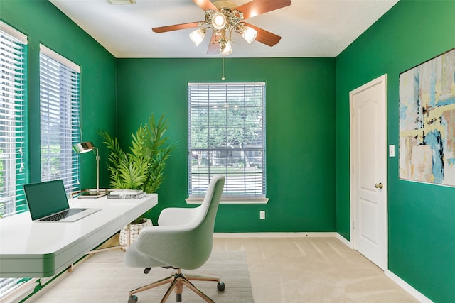 carpeted home office featuring ceiling fan