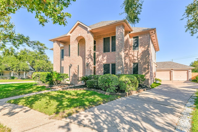 view of front of home with a garage, an outbuilding, and a front yard