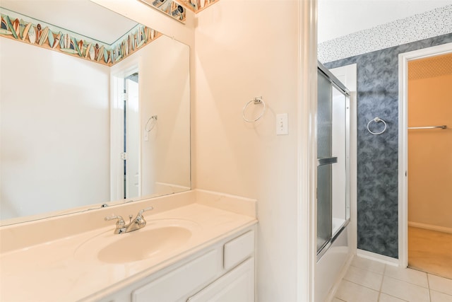 bathroom featuring tile patterned flooring, vanity, and combined bath / shower with glass door