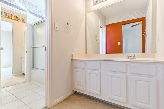 bathroom with tile patterned floors, ceiling fan, vanity, and bath / shower combo with glass door