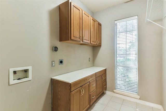 laundry area with cabinets, washer hookup, hookup for an electric dryer, and light tile patterned flooring