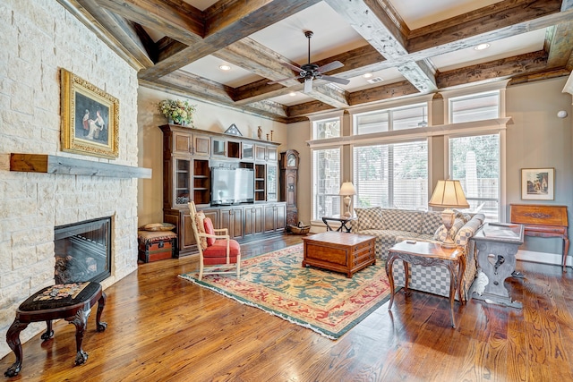 living room featuring beamed ceiling, wood-type flooring, and a healthy amount of sunlight