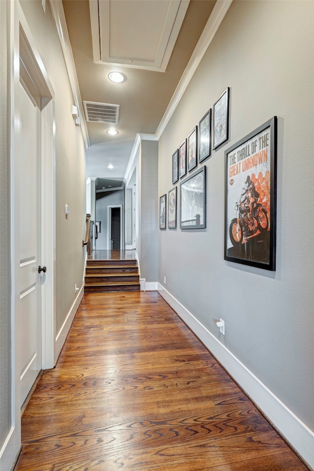 corridor with hardwood / wood-style floors and ornamental molding