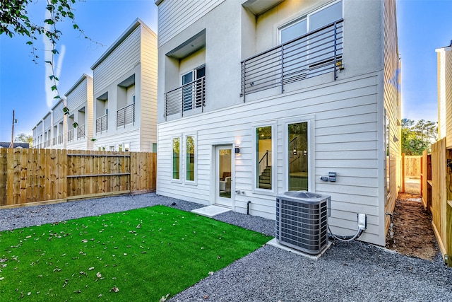 back of house with a yard and central AC