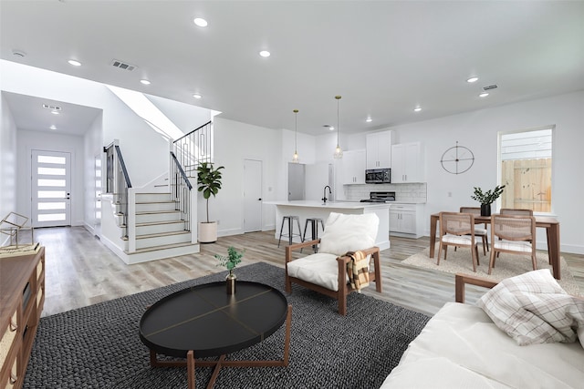 living room featuring light hardwood / wood-style floors and sink