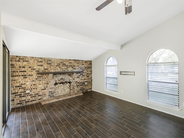 unfurnished living room with ceiling fan, dark hardwood / wood-style floors, lofted ceiling with beams, and brick wall