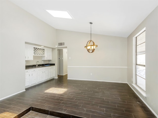 kitchen featuring sink, white cabinets, decorative light fixtures, and dark hardwood / wood-style floors