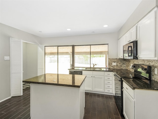 kitchen with black appliances, white cabinets, sink, dark hardwood / wood-style floors, and a kitchen island