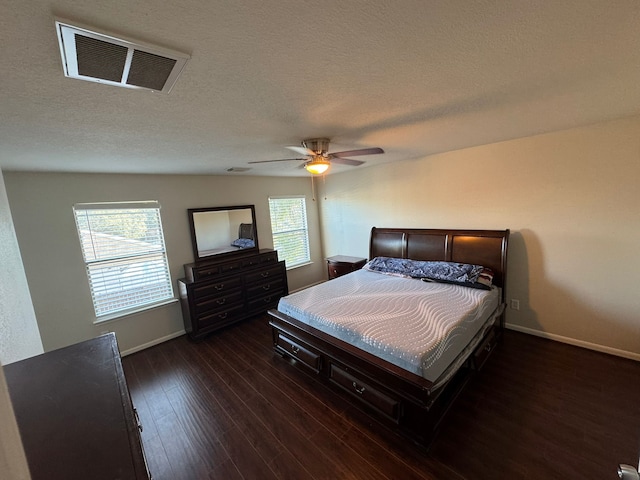 bedroom with multiple windows, ceiling fan, dark hardwood / wood-style flooring, and a textured ceiling