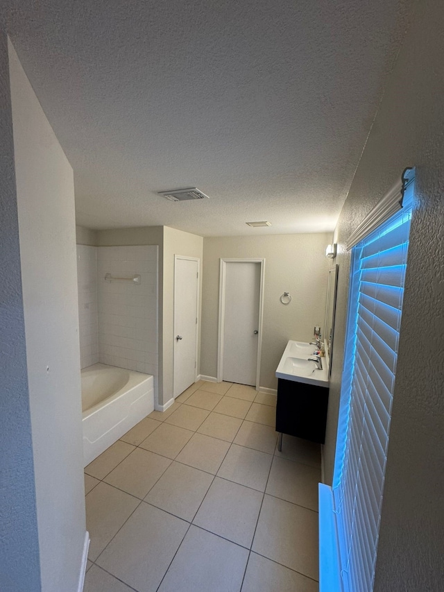 bathroom featuring tile patterned flooring, vanity, and a textured ceiling