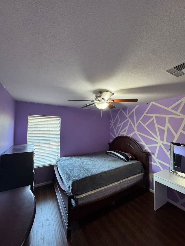 bedroom with a textured ceiling, dark hardwood / wood-style floors, and ceiling fan