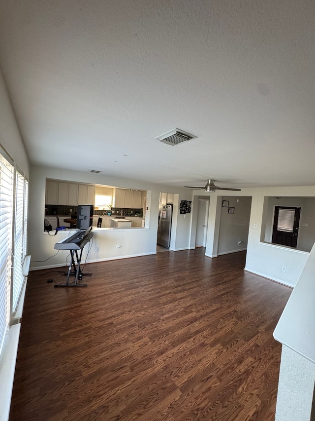 living room with ceiling fan and dark hardwood / wood-style flooring