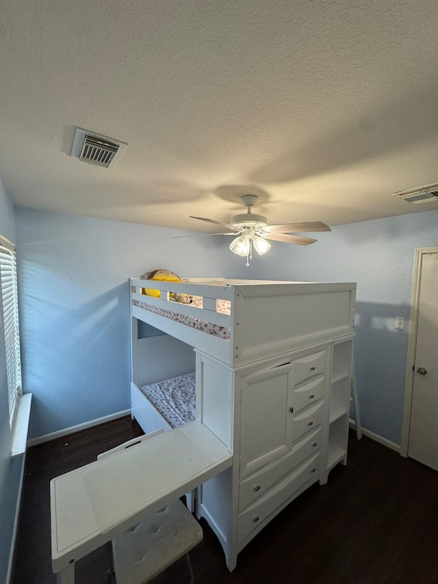 bedroom with ceiling fan and a textured ceiling