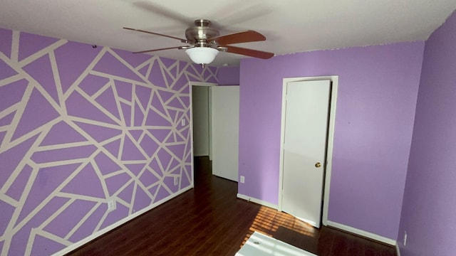 empty room with ceiling fan and dark wood-type flooring