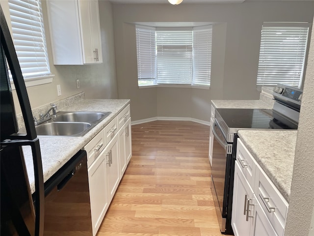 kitchen featuring light wood-type flooring, dishwashing machine, sink, electric stove, and white cabinets