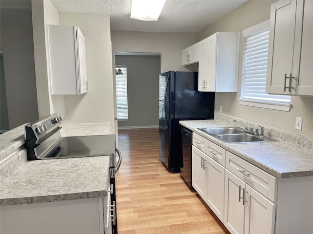 kitchen featuring dishwasher, electric range, white cabinetry, and sink