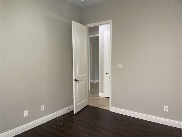 empty room with dark hardwood / wood-style flooring