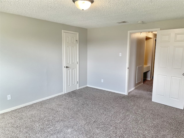 carpeted empty room featuring a textured ceiling