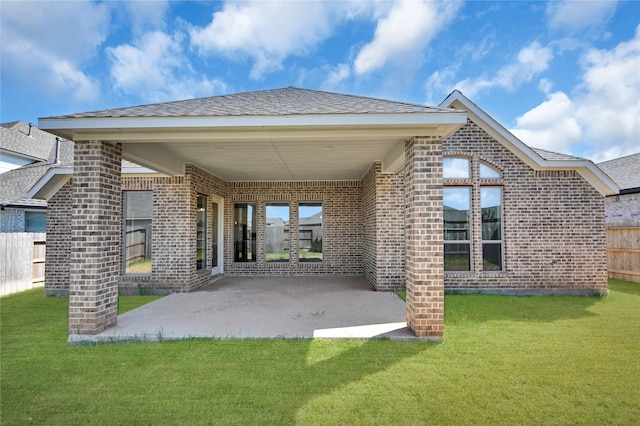 back of house with a patio and a lawn