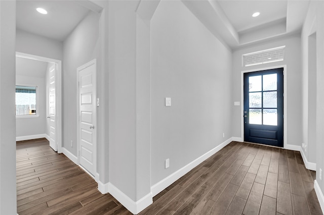 entryway with dark hardwood / wood-style flooring and a healthy amount of sunlight