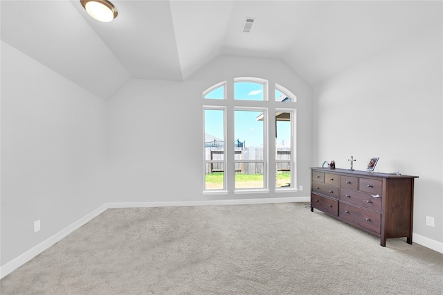 additional living space featuring plenty of natural light, light colored carpet, and lofted ceiling