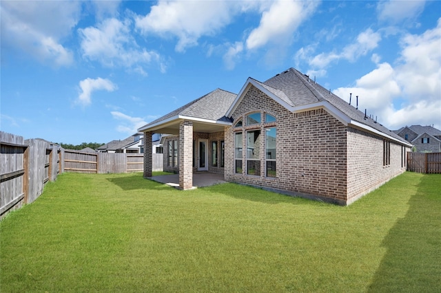 rear view of house with a yard and a patio area