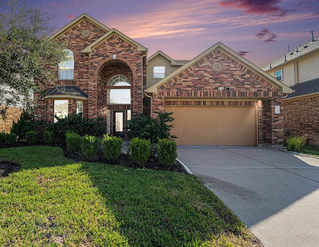 front of property with a garage and a yard